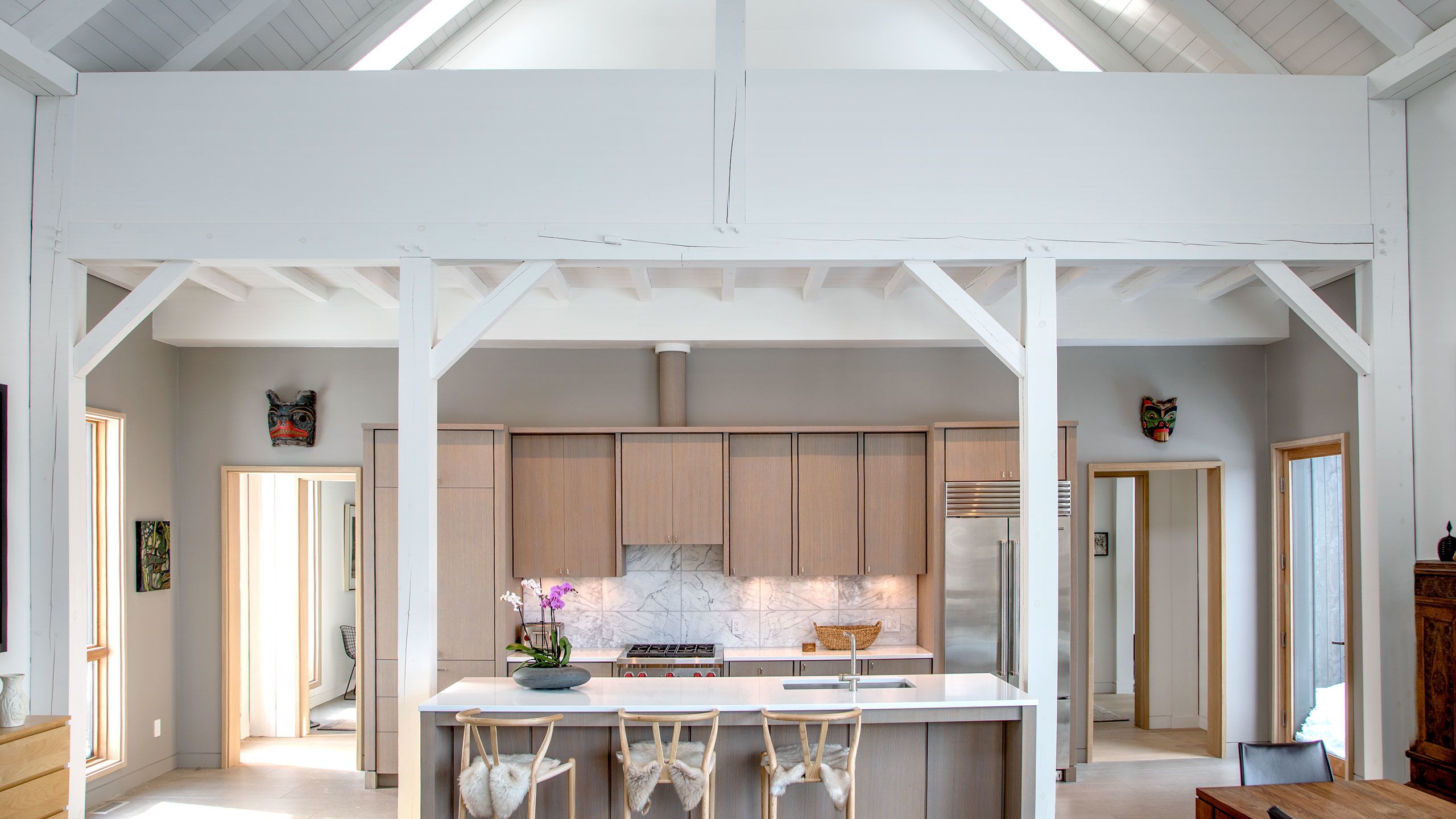 Wideshot of the Kitchen with timber frame and loft area with skylights above.