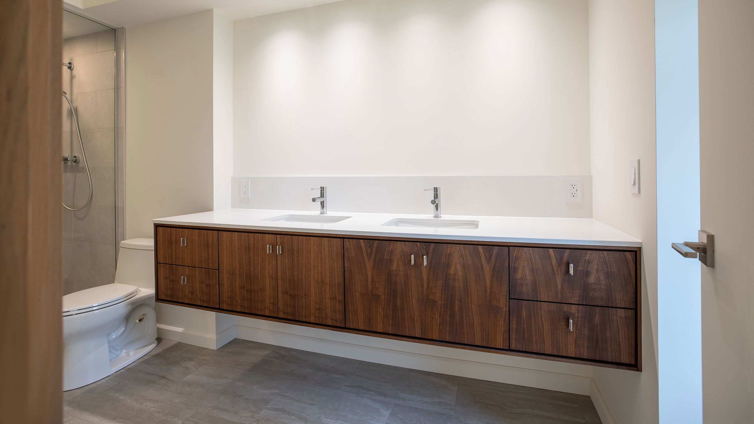 Wide view of walnut bathroom vanity.