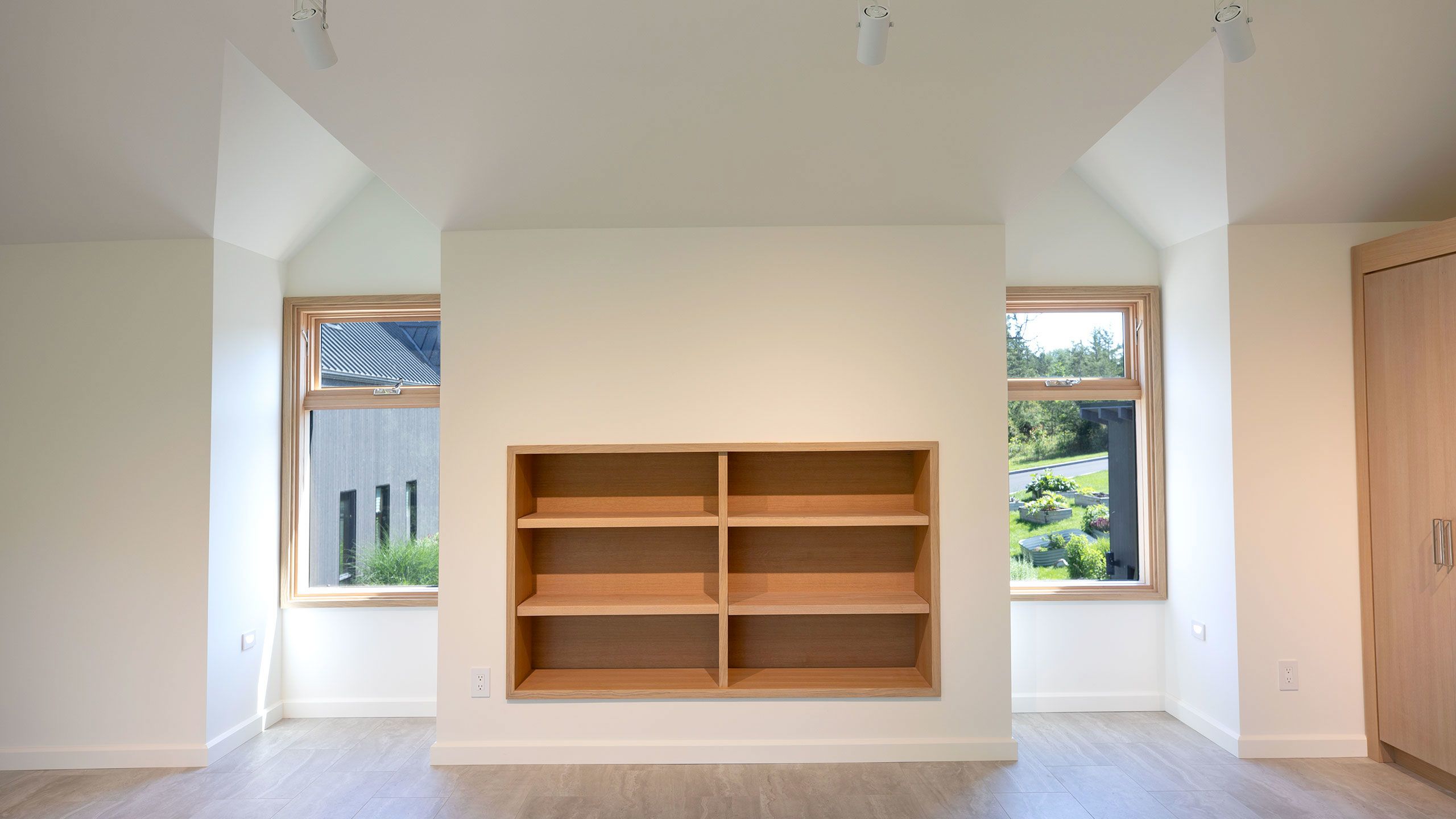 View of the peaked dormer windows with a view of the house and garden. Built in bookcase.