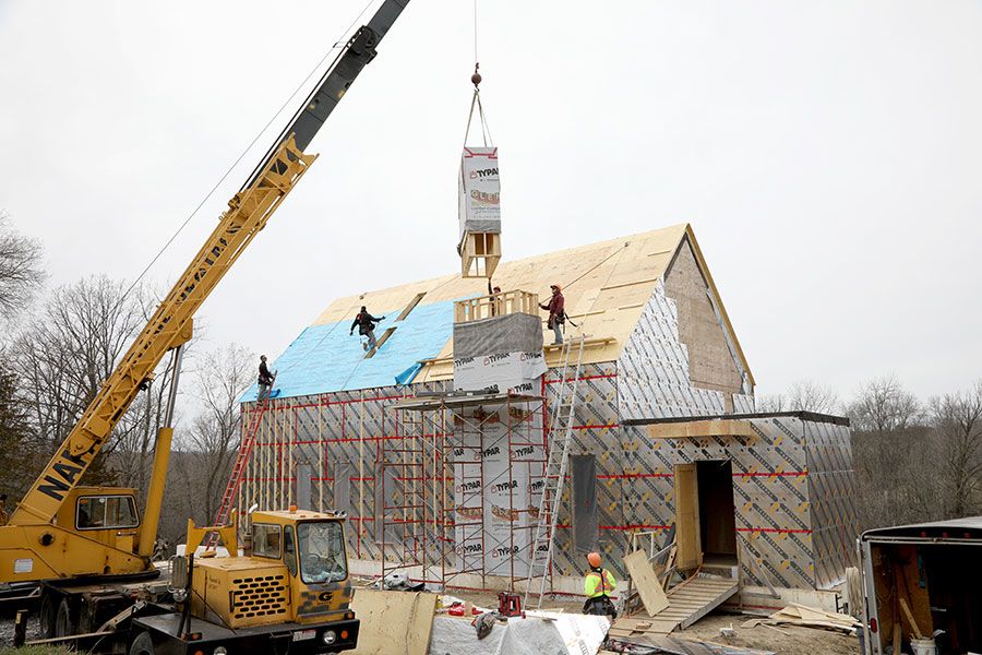 Using a crane to lift the top of the chimney into place. The top is made from wood wrapped in a weather proof sheathing
